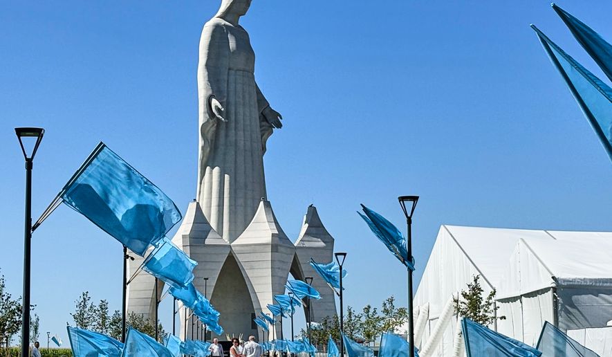 People walk inside an enormous statue of the Virgin Mary that is believed to be Europe's tallest during the inauguration in the village Konotopie, Poland, Saturday, Aug. 15, 2026. (AP Photo/Claudia Ciobanu)