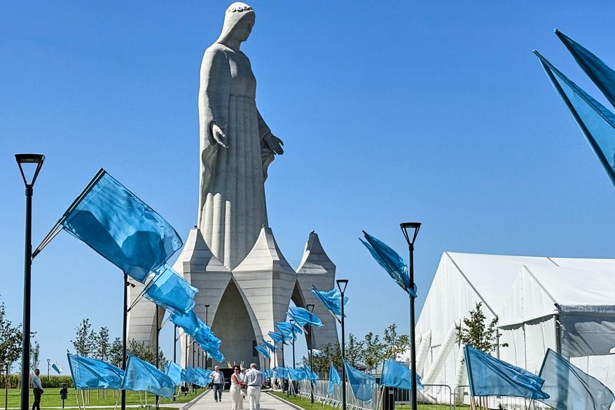 People walk inside an enormous statue of the Virgin Mary that is believed to be Europe's tallest during the inauguration in the village Konotopie, Poland, Saturday, Aug. 15, 2026. (AP Photo/Claudia Ciobanu)