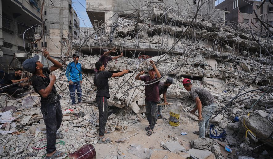 Palestinians remove iron from the rubble of buildings destroyed by Israeli airstrikes during the war with Hamas, repair and recycle it for construction, building tents or selling it, in Gaza City, Sunday, Aug. 16, 2026. (AP Photo/Jehad Alshrafi)