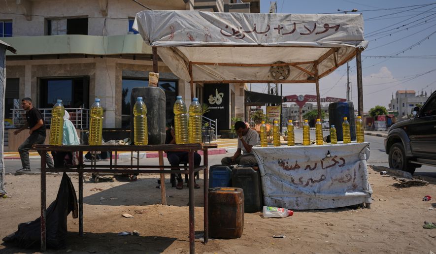 A Palestinian vendor offers bottles of diesel for sale in al-Maghazi refugee camp, central Gaza Strip, Saturday, Aug. 15, 2026. (AP Photo/Abdel Kareem Hana)