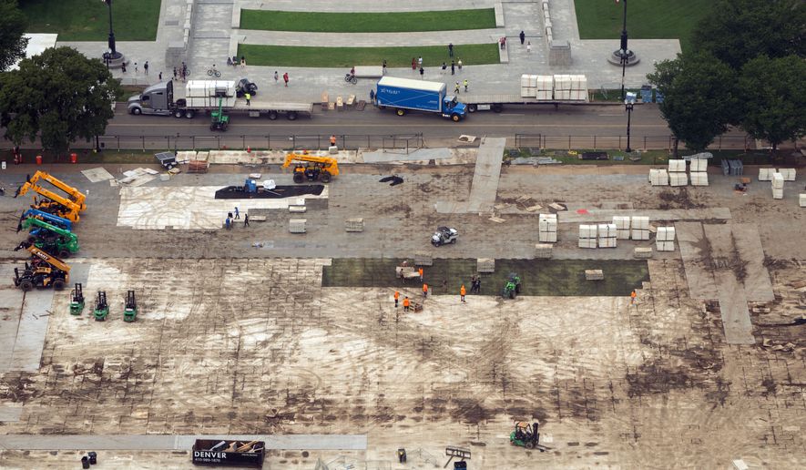 Workers dismantle structures from Salute to America, an Independence Day event honoring the nation's 250th anniversary, as seen from the Washington Monument, on July 10, 2026, in Washington. (AP Photo/Mark Schiefelbein, File)