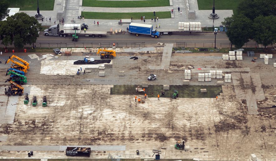 FILE - Workers dismantle structures from Salute to America, an Independence Day event honoring the nation's 250th anniversary, as seen from the Washington Monument, on July 10, 2026, in Washington. (AP Photo/Mark Schiefelbein, File)