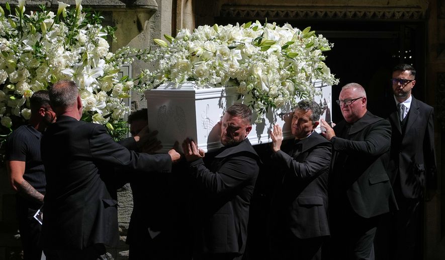 The coffin is taken from Swansea Minster following the funeral of Bonnie Tyler in Swansea, Wales, Monday, Aug. 17, 2026. (AP Photo/Alastair Grant)