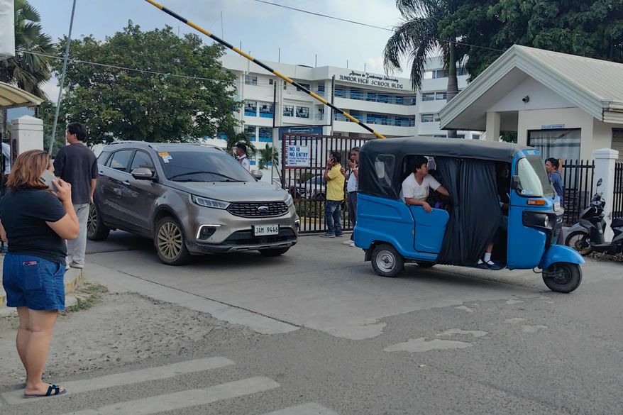 Vehicles exit the Ateneo de Zamboanga University following a shooting incident in Zamboanga, southern Philippines Tuesday, Aug. 18, 2026. (AP Photo) CORRECTION: Corrects date and day