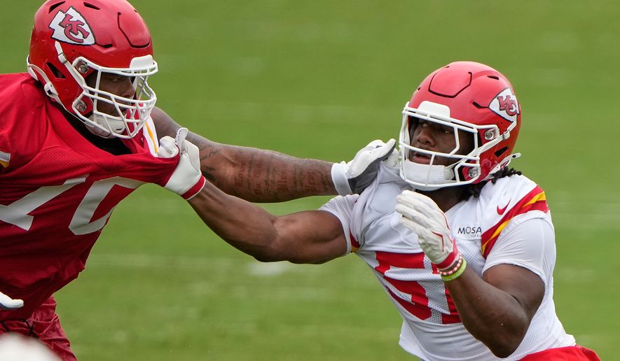 Kansas City Chiefs tackle Kahil Benson, left, and Kansas City Chiefs defensive end R Mason Thomas (51) practice during NFL football training camp Friday, July 31, 2026, in St. Joseph, Mo. (AP Photo/Charlie Riedel)