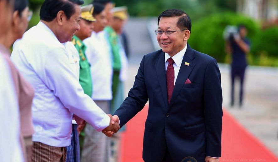 In this photo released by Myanmar President Office, Myanmar President Min Aung Hlaing, right, shakes hands with Lower House Speaker Khin Yi upon his departure to Russia, at the Naypyitaw international airport Monday, Aug. 17, 2026, in Naypyitaw, Myanmar. (Myanmar President Office via AP)