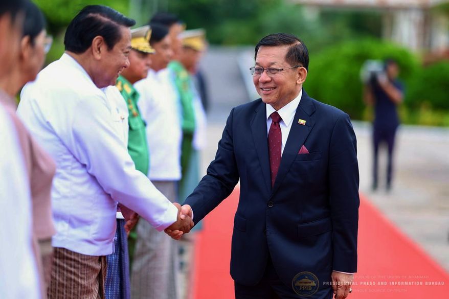 In this photo released by Myanmar President Office, Myanmar President Min Aung Hlaing, right, shakes hands with Lower House Speaker Khin Yi upon his departure to Russia, at the Naypyitaw international airport Monday, Aug. 17, 2026, in Naypyitaw, Myanmar. (Myanmar President Office via AP)