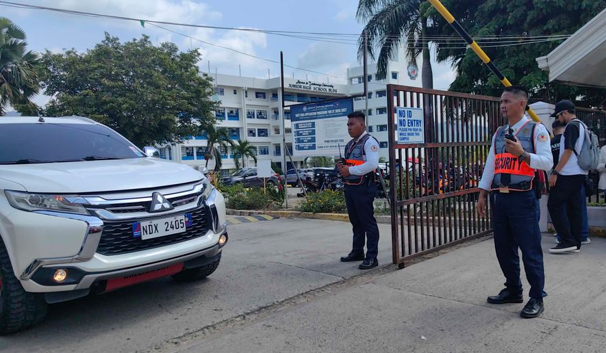 Security guards keep watch as vehicles exit the Ateneo de Zamboanga University following a shooting incident in Zamboanga, southern Philippines Tuesday, Aug. 18, 2026. (AP Photo)