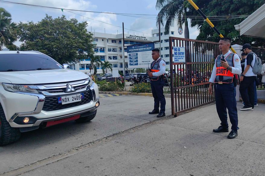 Security guards keep watch as vehicles exit the Ateneo de Zamboanga University following a shooting incident in Zamboanga, southern Philippines Tuesday, Aug. 18, 2026. (AP Photo)