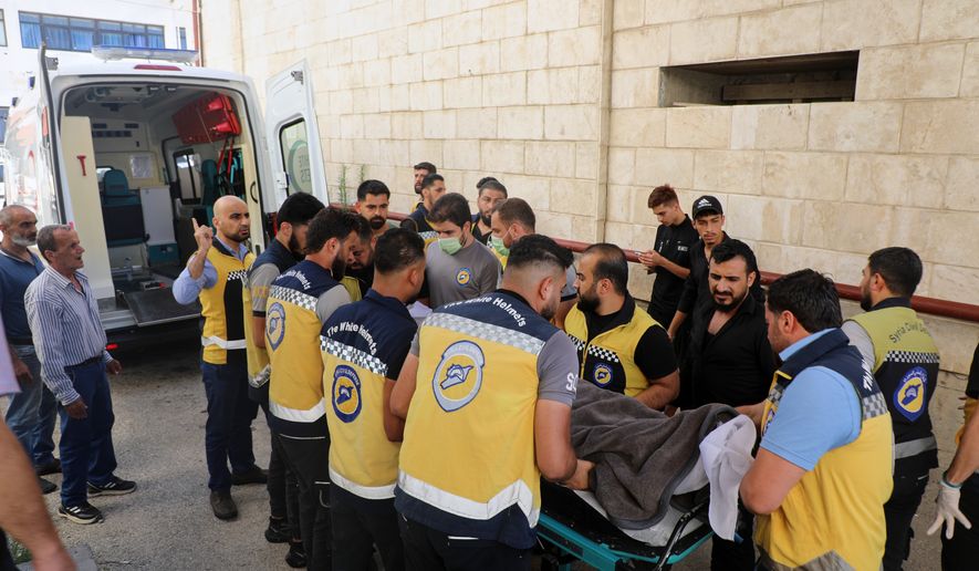 Members of the White Helmets carry the body of Mohammad Ghamira, a former White Helmets volunteer who died shortly after his release from jail, before his burial in the village of al-Haffa, Latakia province, Syria, Monday, Aug. 17, 2026. (AP Photo)
