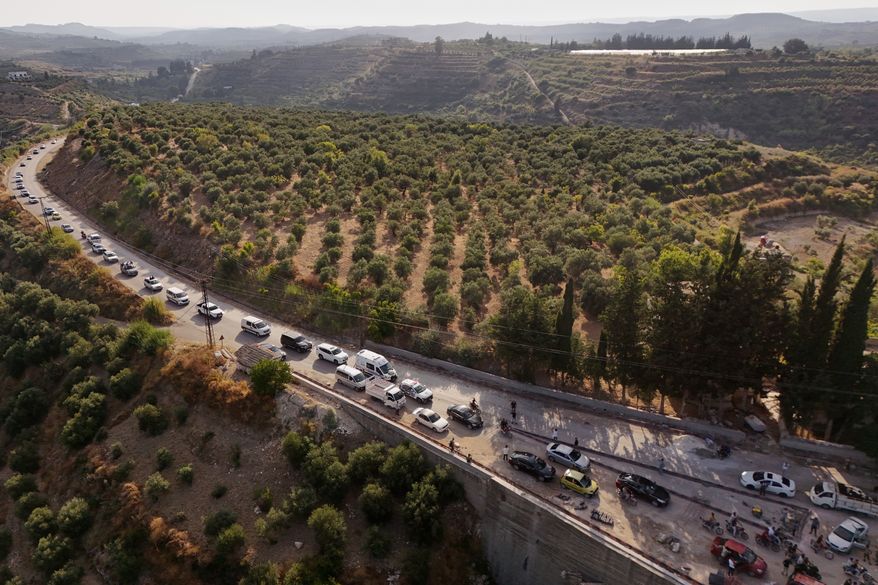 A funeral procession for Mohammad Ghamira, a former White Helmets volunteer who died shortly after his release from jail, travels through the countryside near the village of al-Haffa, in Latakia province, Syria, Monday, Aug. 17, 2026. (AP Photo)