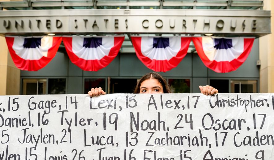 Olivia Konar holds a banner with names of young people who advocates say died as a result of social media outside the Ronald V. Dellums Federal Building and U.S. Courthouse on Tuesday, Aug. 18, 2026, in Oakland, Calif. Her sister Coco Konar died in 2022 when she was 17. (AP Photo/Noah Berger)