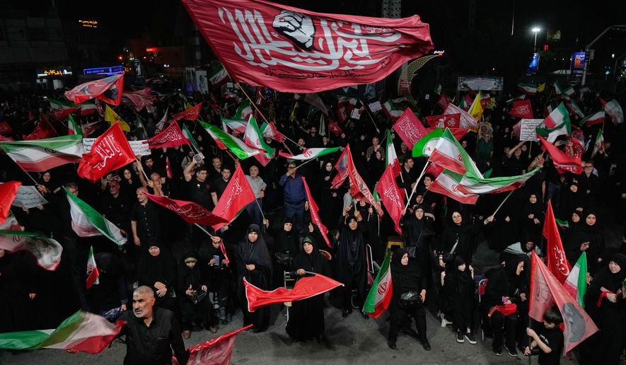 Iranian pro-government demonstrators wave flags in a gathering at a square in Tehran, Iran, Tuesday, Aug. 11, 2026. (AP Photo/Vahid Salemi)