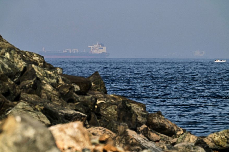 Cargo ships are seen at sea in the Gulf of Oman near the Strait of Hormuz, from a rocky shoreline near Khor Fakkan, United Arab Emirates, May 1, 2026. (AP Photo/Fatima Shbair, File)