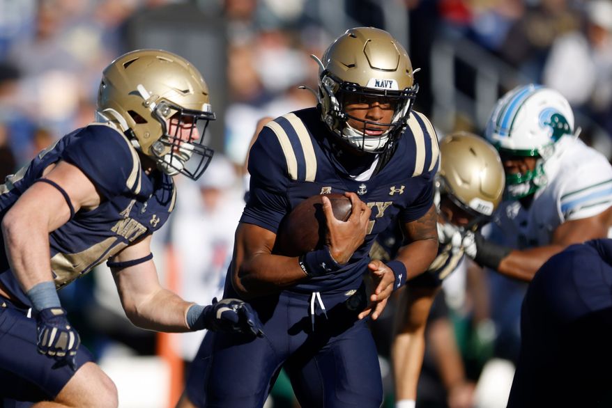 Navy quarterback Braxton Woodson (5) rushes downfield during an NCAA football game against Tulane, Nov. 16, 2024, in Annapolis, Md. (AP Photo/Mike Buscher, File)