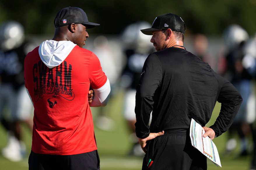 Houston Texans head coach DeMeco Ryans, left, talks with Las Vegas Raiders head coach Klint Kubiak during a joint practice at the NFL football training camp Tuesday, Aug. 18, 2026, in Houston. (AP Photo/Ashley Landis)