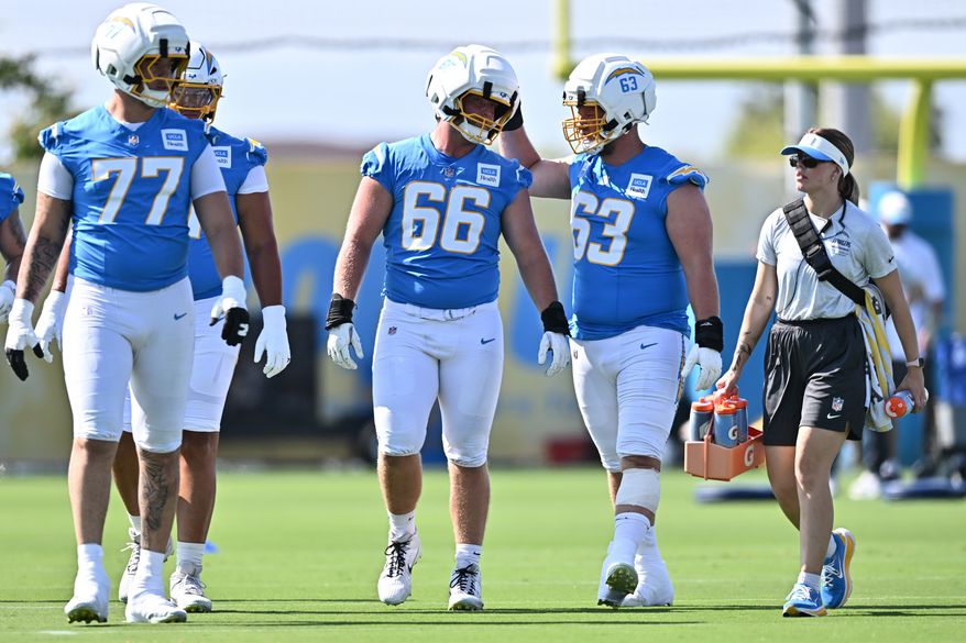 Los Angeles Chargers center Jake Slaughter (66) is greeted by center Tyler Biadasz (63) during practice at the NFL football team's training camp Wednesday, July 29, 2026, in El Segundo, Calif. (AP Photo/William Liang)