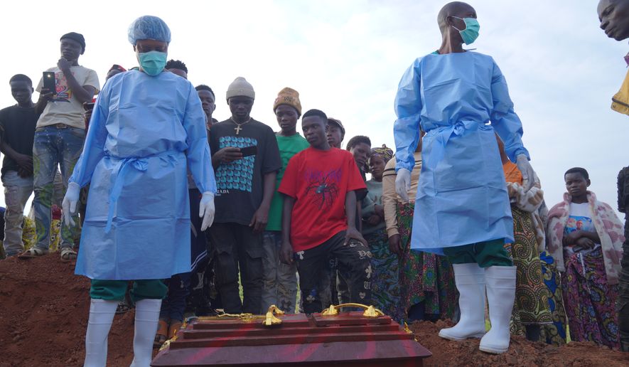People dressed in protective gear prepare to lower into a grave the coffin containing the remains of 3-year-old Mave Mercienne, who died of Ebola, in Bunia, Ituri province, eastern Congo, Tuesday, Aug. 18, 2026. (AP Photo/Dieudonne Dirole)