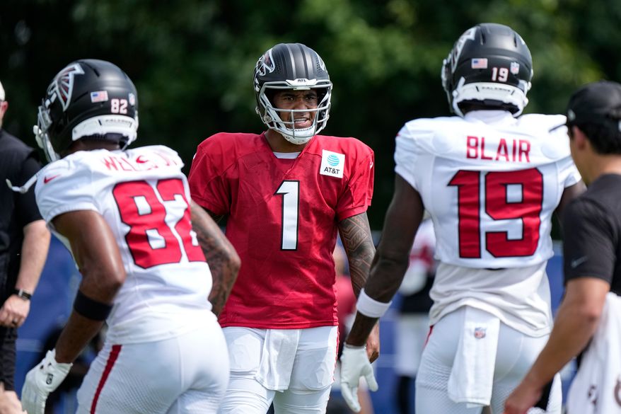Atlanta Falcons quarterback Tua Tagovailoa (1) cuts between wide receiver Antwane Wells Jr. (82) and wide receiver Chris Blair (19) during a joint practice with the Indianapolis Colts at the team's NFL football training camp in Westfield, Ind., Wednesday, Aug. 19, 2026. (AP Photo/Michael Conroy)