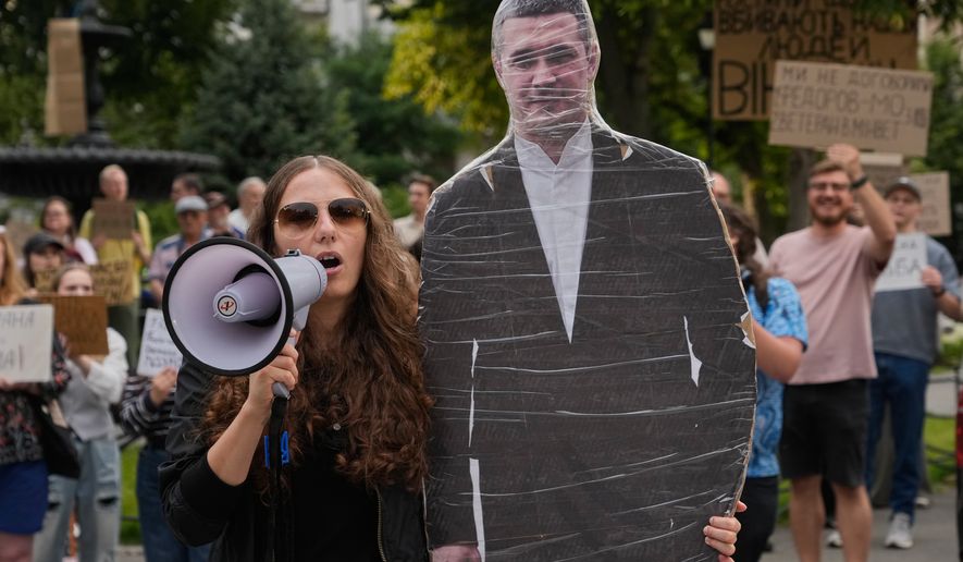 Demonstrators hold a photo of former Defense Minister Mykhailo Fedorov during a rally to denounce President Volodymyr Zelenskyy's decision to dismiss Fedorov after six months in the post, in Kyiv, Ukraine, Friday, July 24, 2026. (AP Photo/Efrem Lukatsky)
