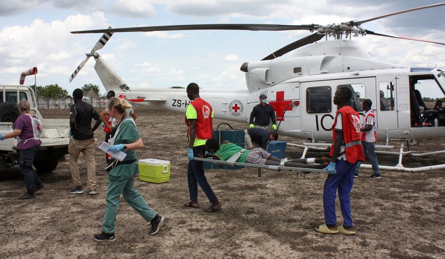 FILE - Medical staff with the International Committee of the Red Cross (ICRC) and South Sudan Red Cross, move a wounded patient to an ambulance in Akobo, South Sudan, May 24, 2025. (AP Photo/Joseph Falzetta, File)