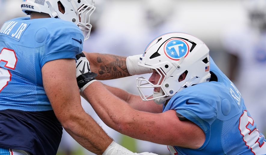 Tennessee Titans guards Jackson Slater, right, runs through a drill with Fernando Carmona Jr., left, during the NFL football team's training camp Tuesday, Aug. 4, 2026, in Nashville, Tenn. (AP Photo/George Walker IV)