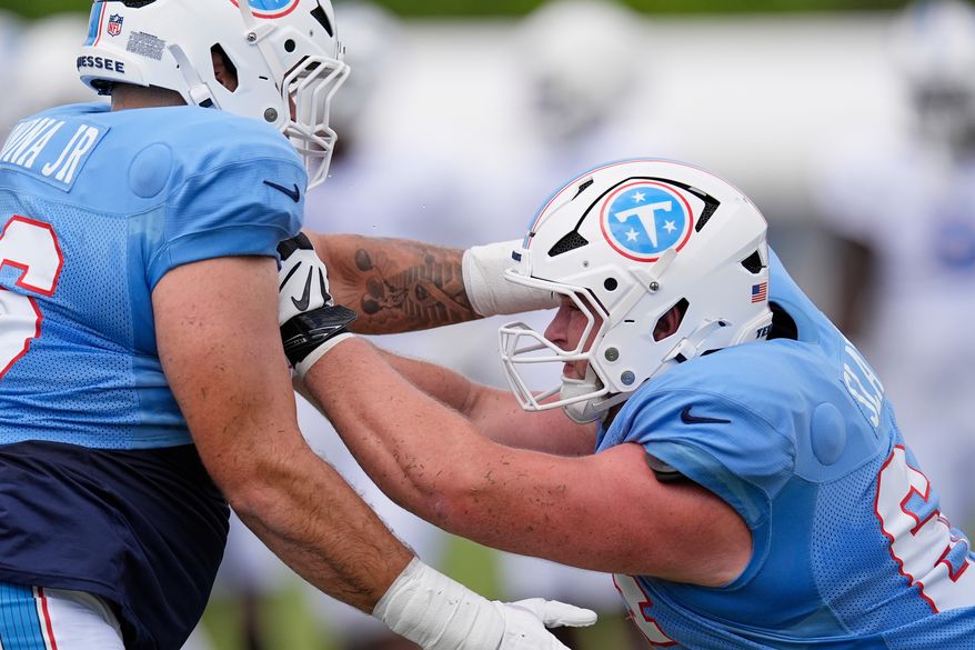 Tennessee Titans guards Jackson Slater, right, runs through a drill with Fernando Carmona Jr., left, during the NFL football team's training camp Tuesday, Aug. 4, 2026, in Nashville, Tenn. (AP Photo/George Walker IV)
