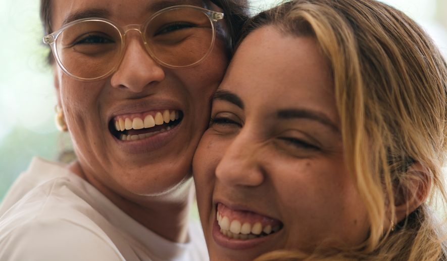 Newlyweds Scarlett Rocha, right, and Fabiana Justiniano pose for a photo at their home in Santa Cruz, Bolivia, Saturday, Aug. 15, 2026. (AP Photo/Juan Karita)
