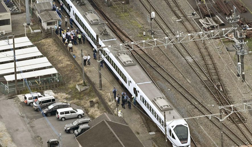 This aerial photo shows, the Spacia X express train stopped after coming into contact with four workers at Shin-Kanuma Station on the Tobu Nikko Line in Kanuma, north of Tokyo, Thursday, Aug. 20, 2026. (Kyodo News via AP)