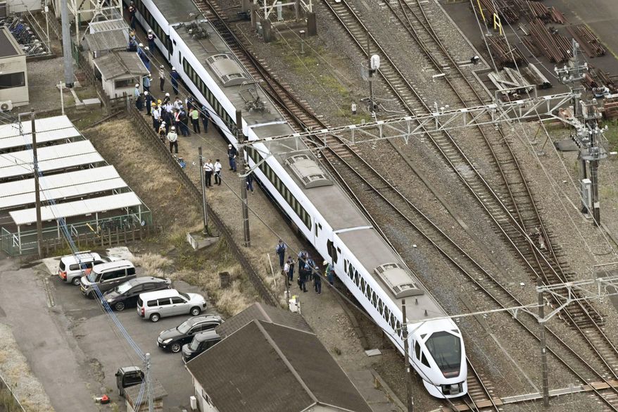 This aerial photo shows, the Spacia X express train stopped after coming into contact with four workers at Shin-Kanuma Station on the Tobu Nikko Line in Kanuma, north of Tokyo, Thursday, Aug. 20, 2026. (Kyodo News via AP)
