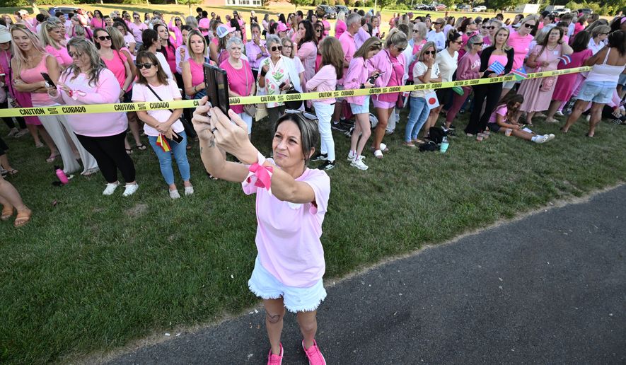 Aimee Breault of Acushnet, Mass., live-streams a demonstration in support of Lindsay Clancy outside Plymouth Superior Court, where Clancy is on trial in connection with the deaths of her three children, Thursday, Aug. 20, 2026, in Plymouth, Mass. (AP Photo/Josh Reynolds )