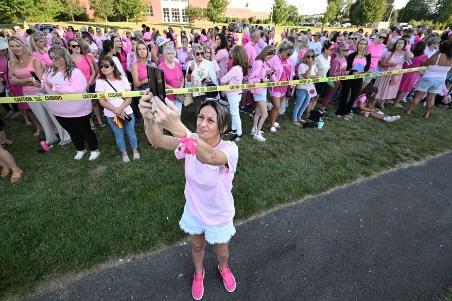 Aimee Breault of Acushnet, Mass., live-streams a demonstration in support of Lindsay Clancy outside Plymouth Superior Court, where Clancy is on trial in connection with the deaths of her three children, Thursday, Aug. 20, 2026, in Plymouth, Mass. (AP Photo/Josh Reynolds )