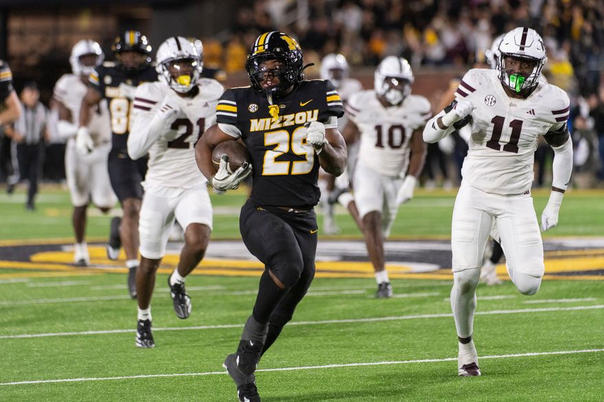 FILE - Missouri running back Ahmad Hardy (29) runs past Mississippi State linebacker Tyler Lockhart (11) and safety Hunter Washington (21) during the second half of an NCAA college football game Nov. 15, 2025, in Columbia, Mo. (AP Photo/L.G. Patterson, File)