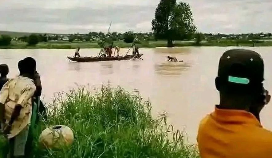 People gather at the site where a boat capsized in Sokoto, northwestern Nigeria, Thursday, Aug. 20, 2026. (AP Photo/Usman Yusuf)