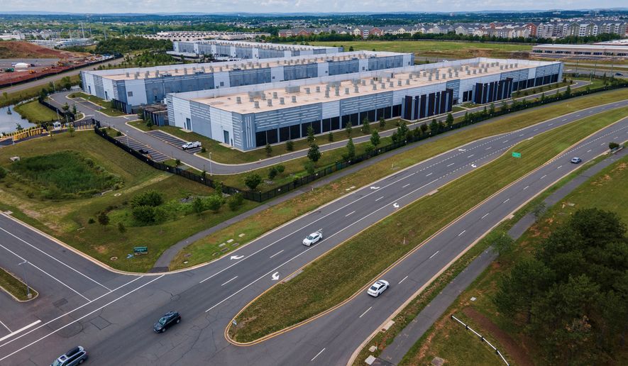 FILE - Cars drive past data centers, July 16, 2023, in Ashburn, Va. (AP Photo/Ted Shaffrey, File)