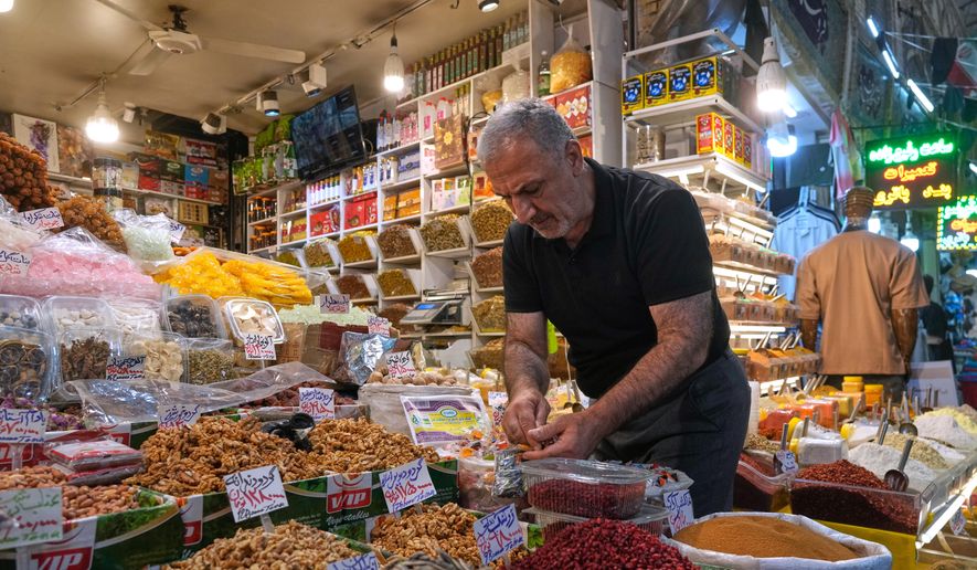 A shopkeeper arranges nuts at his shop at Tajrish traditional bazaar in northern Tehran, Iran, Sunday, Aug. 2, 2026. (AP Photo/Vahid Salemi) ** FILE **
