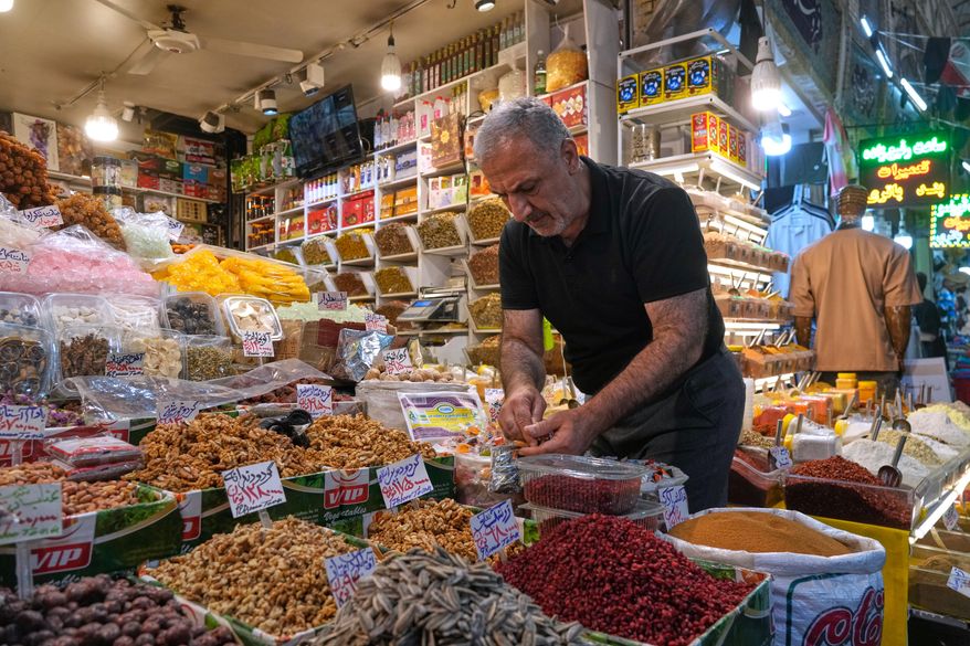 A shopkeeper arranges nuts at his shop at Tajrish traditional bazaar in northern Tehran, Iran, Sunday, Aug. 2, 2026. (AP Photo/Vahid Salemi) ** FILE **