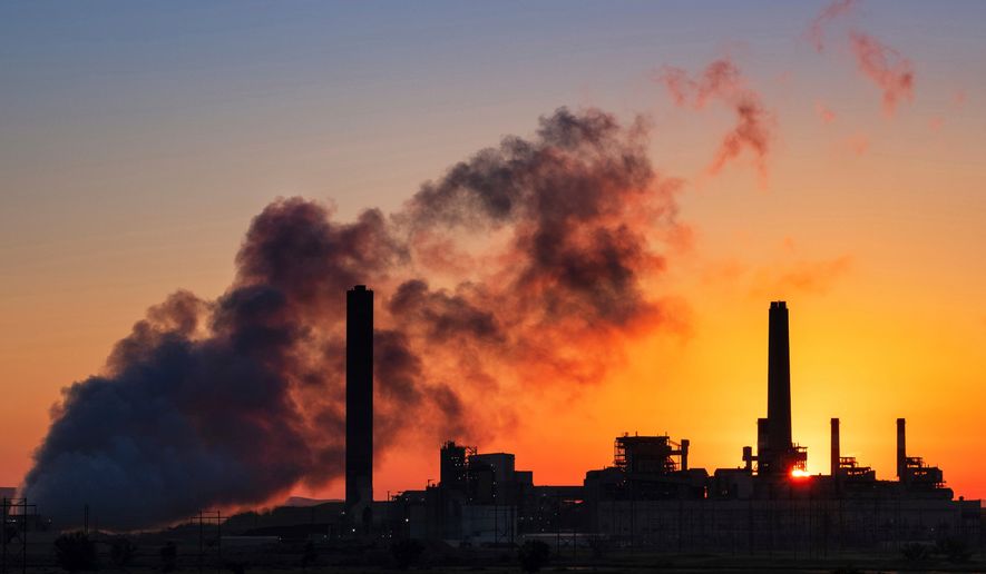 FILE - The Dave Johnson coal-fired power plant is silhouetted against the morning sun in Glenrock, Wyo., July 27, 2018 (AP Photo/J. David Ake, File)