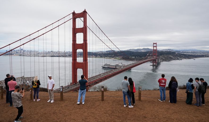 People look at and photograph the Golden Gate Bridge while visiting Marin Headlands, which is part of the Golden Gate National Recreation Area, Oct. 1, 2025, in Mill Valley, Calif. (AP Photo/Godofredo A. Vásquez, File)