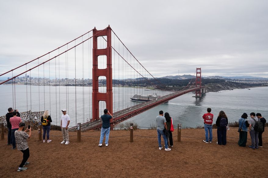 People look at and photograph the Golden Gate Bridge while visiting Marin Headlands, which is part of the Golden Gate National Recreation Area, Oct. 1, 2025, in Mill Valley, Calif. (AP Photo/Godofredo A. Vásquez, File)