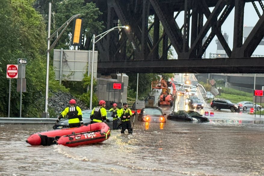 In this photo provided by the City of Jersey City, first responders try to rescue people stranded in a flooded street in Jersey City, N.J., Thursday, Aug. 20, 2026, after storms went through the area. (City of Jersey City via AP)