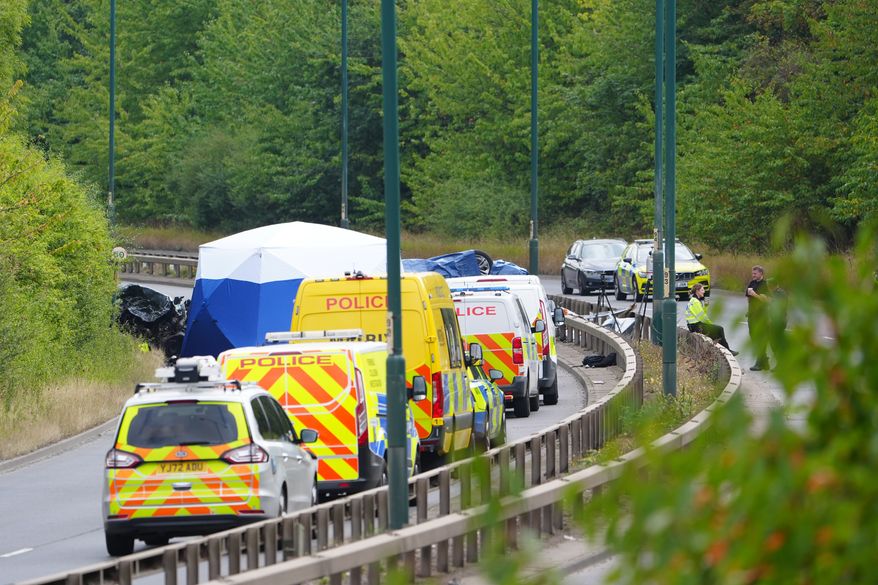 Police officers at the scene of a fatal crash involving a police car and a Volkswagen Passat on the A66 in South Bank, near Middlesbrough, England, Saturday Aug. 22, 2026. (Owen Humphreys/PA via AP)