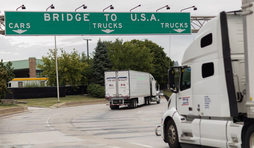Transport trucks cross the Ambassador Bridge into the United States of America, in Windsor, Ontario, Canada, Saturday, Aug. 22, 2026. (Dax Melmer/The Canadian Press via AP)