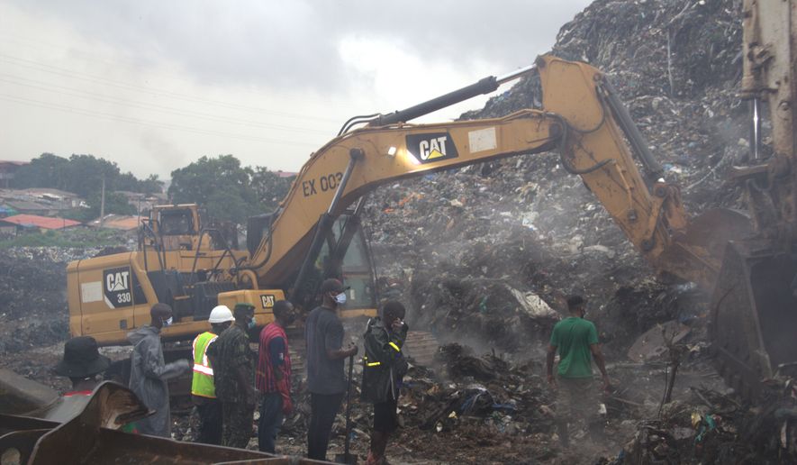 Rescue workers search through a heap of refuse after it collapsed at Conakry’s largest landfill, Guinea, Sunday, Aug. 23, 2026. (AP Photo/Fodo Toure)