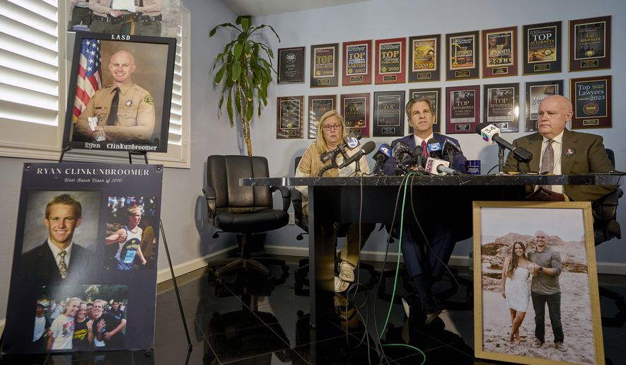 Attorney Bradley Gage, middle, and Kim and Mike Clinkunbroomer, the parents of late Los Angeles Sheriff's Deputy Ryan Clinkunbroomer, announce the precursor to a lawsuit against the Sheriff's Department at a news conference in Los Angeles on Tuesday, Nov. 28, 2023. Los Angeles County Sheriff's Deputy Clinkunbroomer was shot and killed Sept. 16, 2023, while sitting in his patrol car in Palmdale, Calif. His parents are seeking justice for their son and looking to make a change in LACSD's policies to protect other deputies from death. (AP Photo/Damian Dovarganes) **FILE**