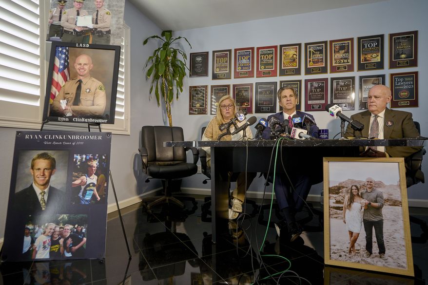 Attorney Bradley Gage, middle, and Kim and Mike Clinkunbroomer, the parents of late Los Angeles Sheriff's Deputy Ryan Clinkunbroomer, announce the precursor to a lawsuit against the Sheriff's Department at a news conference in Los Angeles on Tuesday, Nov. 28, 2023. Los Angeles County Sheriff's Deputy Clinkunbroomer was shot and killed Sept. 16, 2023, while sitting in his patrol car in Palmdale, Calif. His parents are seeking justice for their son and looking to make a change in LACSD's policies to protect other deputies from death. (AP Photo/Damian Dovarganes) **FILE**