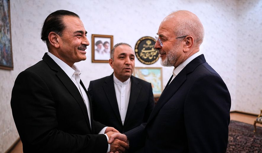 In this photo released by Islamic Consultative Assembly News Agency, ICANA, Iran's parliament Speaker and top negotiator Mohammad Bagher Qalibaf, right, shakes hands with Pakistan's Army Chief Field Marshal Gen. Asim Munir during their meeting in Tehran, Iran, Monday, Aug. 24, 2026. (Mahmoud Hosseini/ICANA via AP)