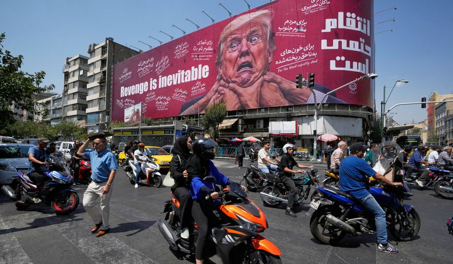 Motorcyclists pass a billboard depicting U.S. President Donald Trump with hands around his neck beneath the words "Revenge is inevitable" in Tehran, Iran, Monday, Aug. 24, 2026. (AP Photo/Vahid Salemi)