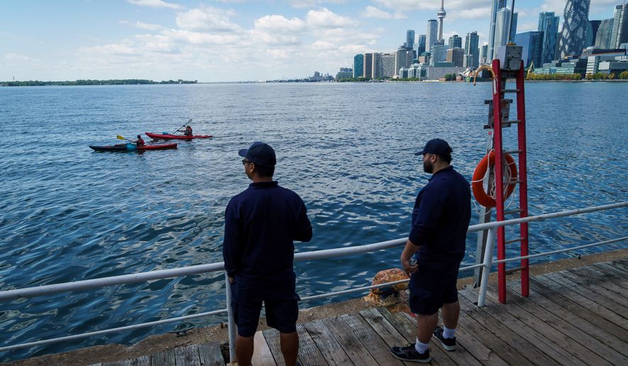 People look out across Lake Ontario from the harbor in Toronto, Tuesday, Aug. 25, 2026. (Keito Newman/The Canadian Press via AP)