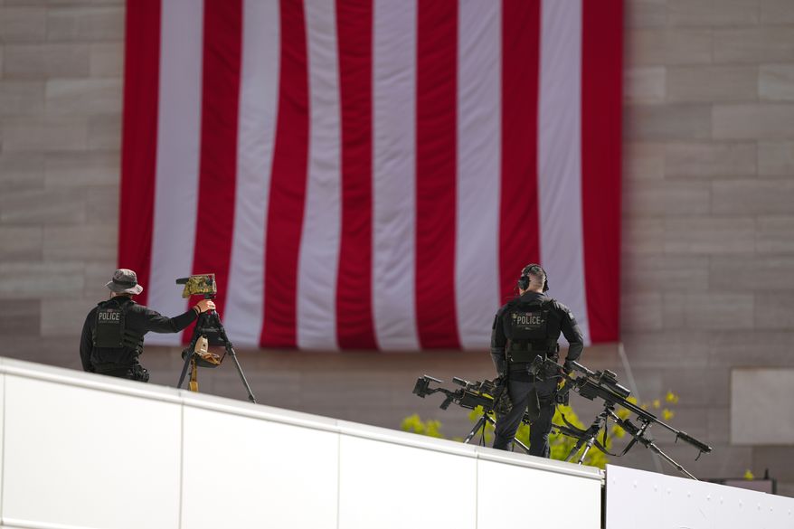 Members of the U.S. Secret Service police conduct overwatch during the IndyCar Freedom 250 Grand Prix auto race, Sunday, Aug. 23, 2026, in Washington. (AP Photo/Julia Demaree Nikhinson)